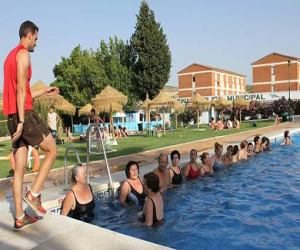 Cerca de una veintena de personas de todas las edades participan en la primera clase de "aquagym"