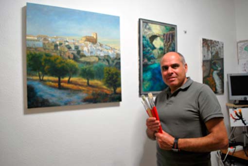 Diego Ramos junto a varios de sus cuadros dedicados a Alhama 