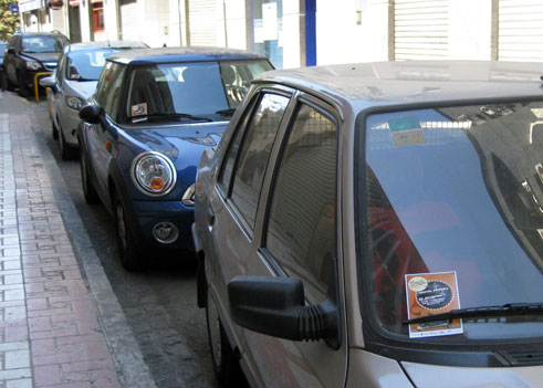 Vehículos aparcados en una calle de Granada con voletas del Festival Vehículos aparcados en una calle de Granada con voletas del Festival