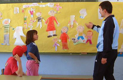 Antonio Bustos junto con una alumna preparan un mural